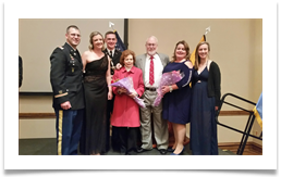 On Stage L-R: LTC Joshua Mau, His Wife Kelly, Matthew Walters, Raqui, Col. Ed Ramsey Jr., Kristin Walters, Cadet Ashley